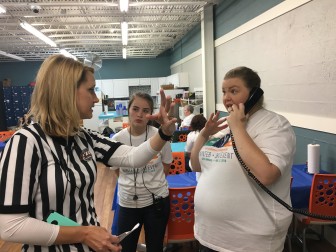 Brenda Cantrell, left, brand ambassador for the Unclaimed Baggage Center, meets with staffers. She started wearing a ref shirt during the annual winter sale a few years ago after shoppers got rowdy. 