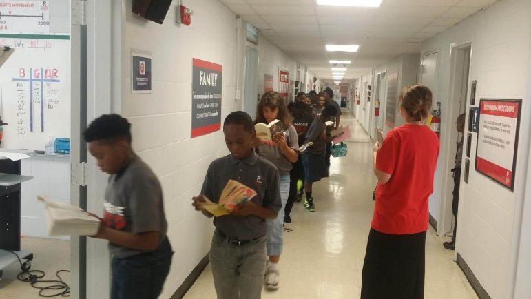 Students at ReImagine Prep in Jackson, Mississippi read in the hallway on their way to class. Credit: Paul Boger
