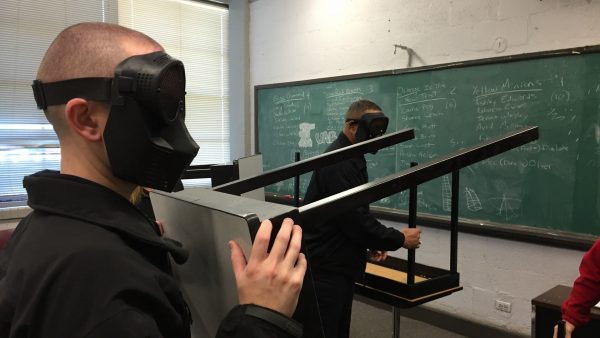 Police officers barricade a door against a pretend active shooter. They're learning the ALICE program so they can train others.