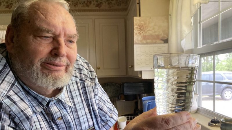 David Koehn, general manager of Black Bayou Water Association, holds up a clear glass of water from his tap, in an area known for naturally-brown water.