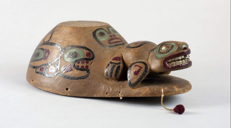 Small wooden “Aleut style” dance hat with a pattern called Tsaa Yaa Ayáanasnakh Kéet (Killerwhale-Chasing-A-Seal) carved on it. One of three objects being returned to the Native American tribes.
