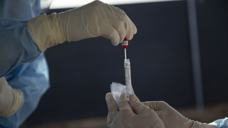 A health care worker administers a swab test for COVID-19.