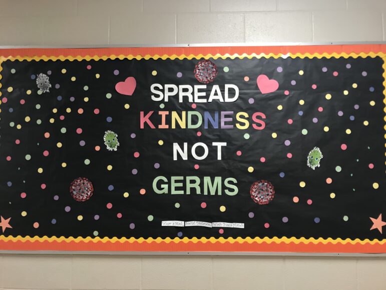 A bulletin board reads "Spread Kindness Not Germs"