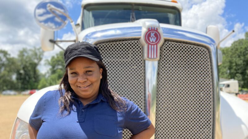 Pamela Williams, a truck driving instructor with DSC Training Academy, stands in front of one of the academy’s trucks. June 29, 2021