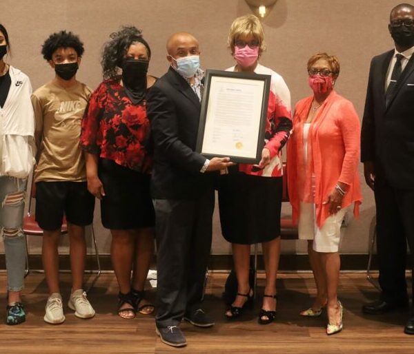 https://wbhm.org/wp-content/uploads/2021/08/Shelly_Millender_III_w_proclamation_from_full_BPL_board_7_n-e1628790456401-600x514.jpg