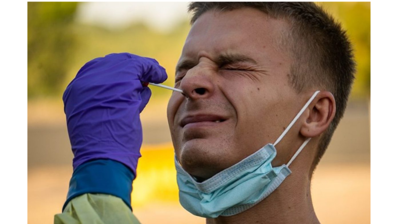 A health care worker administers a swab test for COVID-19.