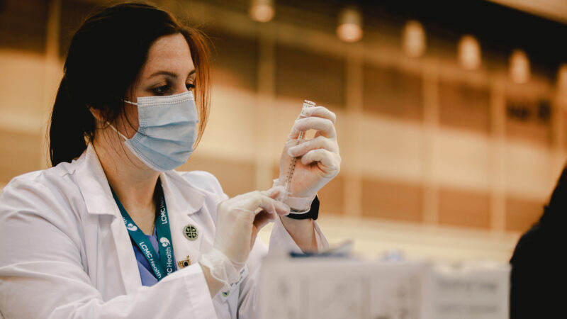 A vaccinator administers a dose of a COVID-19 vaccine at the Ernest N. Morial Convention Center in New Orleans.