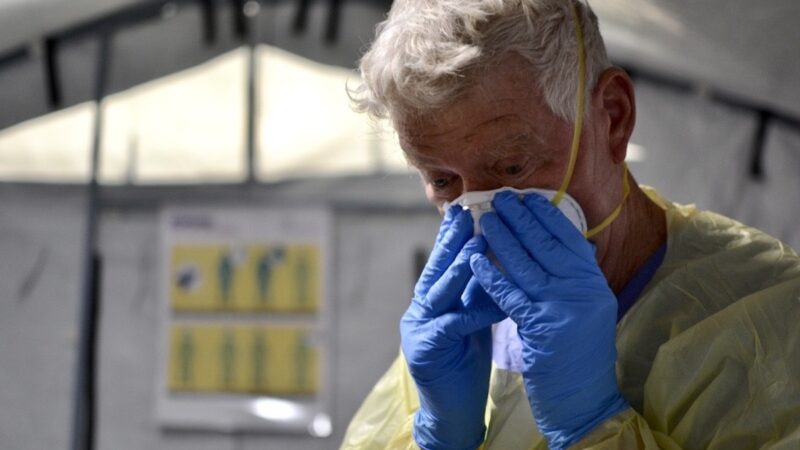 Registered Nurse John Morris with Samaritan's Purse, an international disaster relief organization, puts on layers of personal protective equipment as he leaves the uncontaminated tent to go into tents with critically ill COVID-19 patients at a field hospital outside University of Mississippi Medical Center in Jackson, Mississippi.