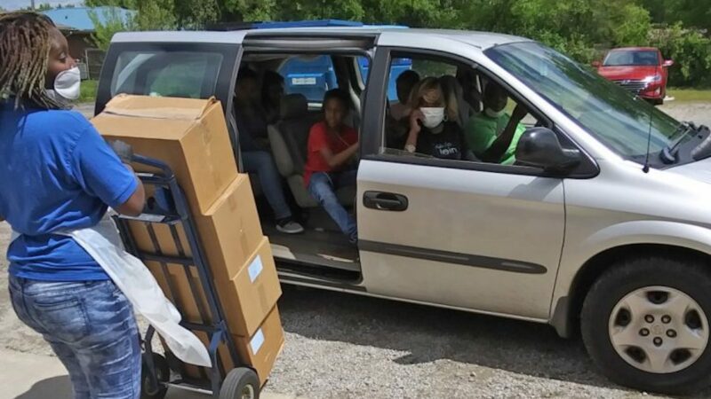 A worker at Project Hopewell wheels food out to members of the community.