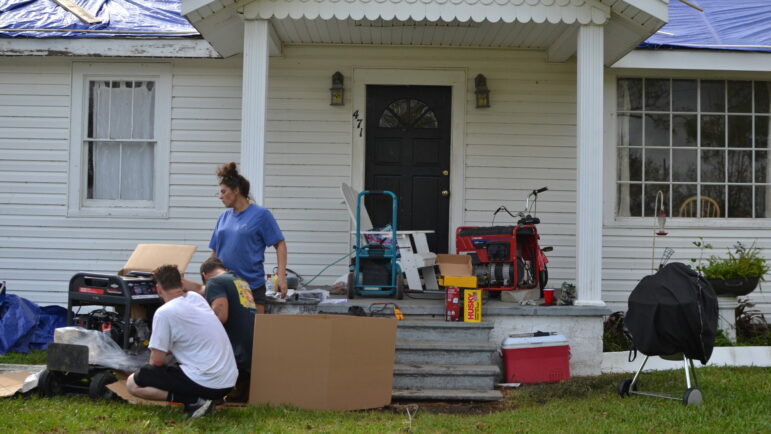 A family across from the Norco plant in LaPlace, Louisiana tries to start up a generator on Tuesday, Aug. 31, 2021, two days after Hurricane Ida struck. In disaster situations — whether natural or financial — Louisiana charities say giving people money is faster and gives them back agency as opposed to waiting for other forms of relief.