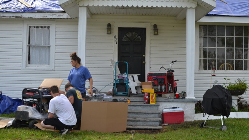 A family across from the Norco plant in LaPlace, Louisiana tries to start up a generator on Tuesday, Aug. 31, 2021, two days after Hurricane Ida struck. In disaster situations — whether natural or financial — Louisiana charities say giving people money is faster and gives them back agency as opposed to waiting for other forms of relief.