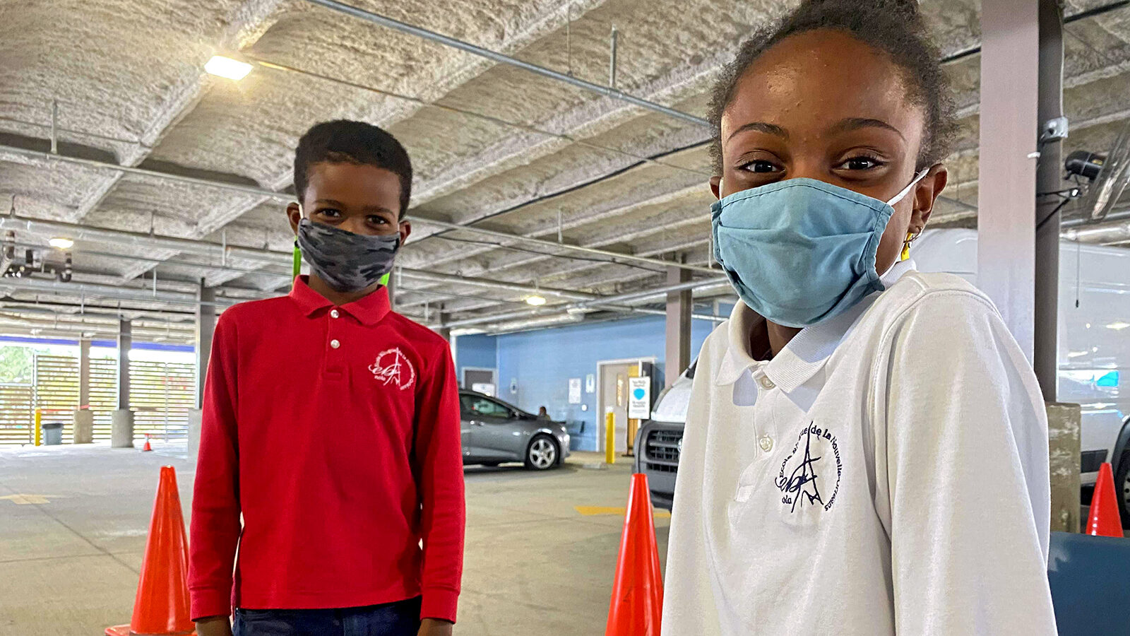 Langston, 8, stands next to his sister Alexia, 11, as they arrive to New Orleans' Crescent Care to receive their COVID-19 vaccine shot.
