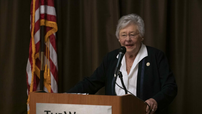 Alabama Governor Kay Ivey speaks behind a podium at the Alabama Military Law Symposium in August 2021