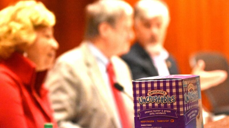 Jefferson County Commissioners sit behind a box of Smucker's Uncrustables.