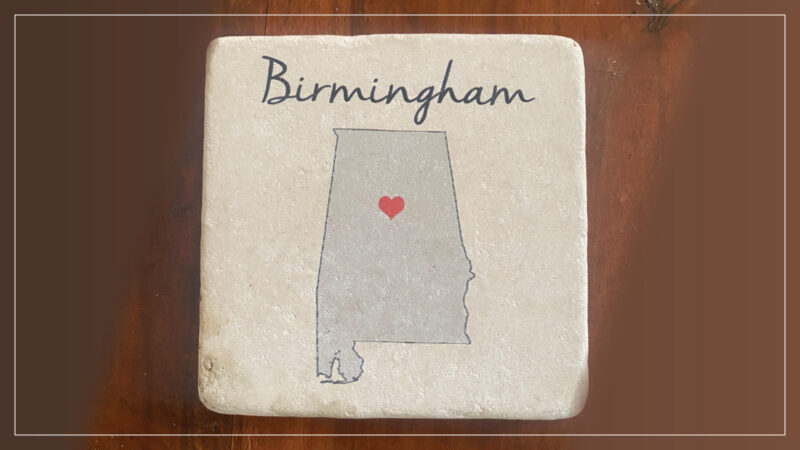A coaster shows the outline of the state of Alabama with a heart over Birmingham