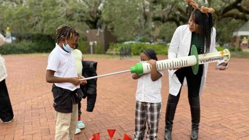 Cali Bell pretends to give her brother Calvin Bell a giant COVID-19 shot, with some help from Louisiana Region One medical director Shantel Hébert-Magee at Louisiana Department of Health vaccine clinic in New Orleans.