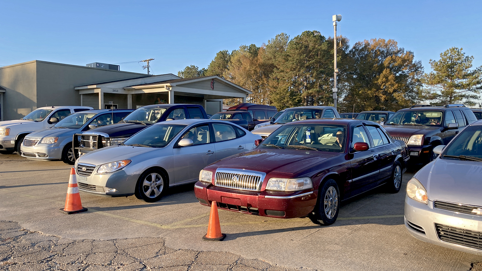 Six rows of cars wait in the parking lot of the the Saint Luke's Food Pantry to receive food and supplies.