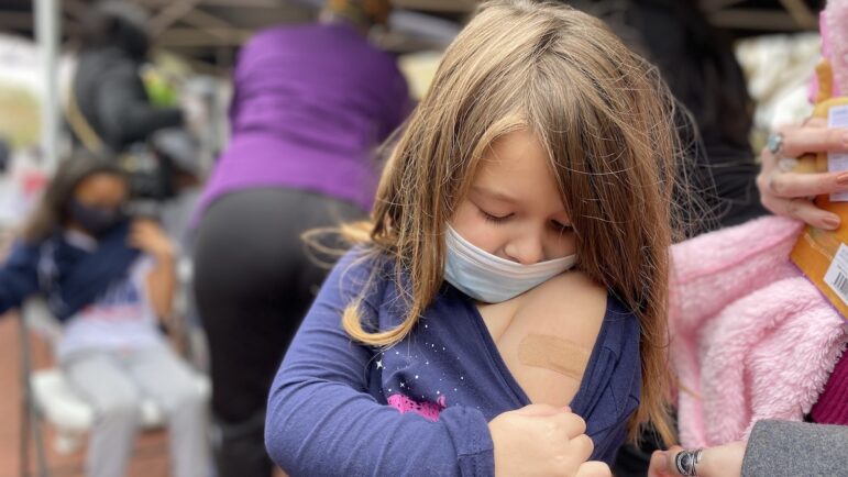 Five year old Vivian Dominguez shows off her band aid after getting a Pfizer COVID-19 shot from a Louisiana Department of Health vaccine clinic in New Orleans.