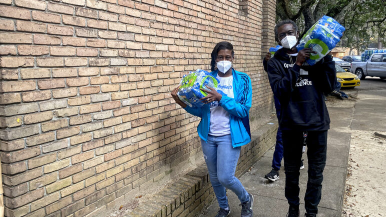 Volunteers with community organization Operation Good deliver cases of water to South Jackson residents.