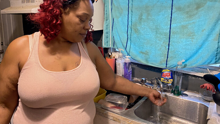 South Jackson resident Baylis McDaniels runs water from the tap in her home.