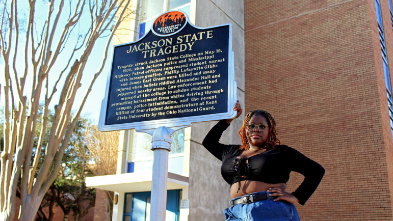 Jackson State University senior Aria Brent stands next to a marker commemorating the Jackson State Tragedy