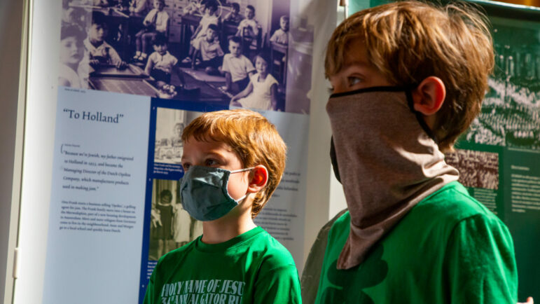 Holy Name of Jesus School fifth-graders Logan Edmond (left) and Charlie Blackwell (right) listen to a tour guide as they walk through a traveling exhibition titled "Anne Frank: A History for Today" at Loyola University of New Orleans.