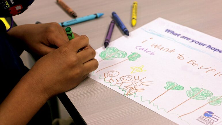 Caleb, a kindergartener, draws a picture of his hopes and dreams during “lunch and learn” at Edgewood Elementary.