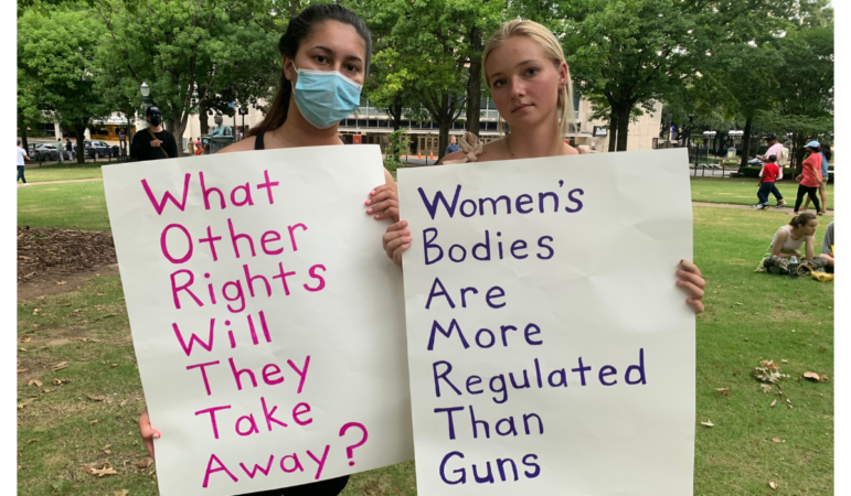 Reed Jeffries stands Ruby Sloan during the rally. Jeffries said she was raped and took Plan B. Sloan has two brothers that are adopted and her mom was a social worker. She said the adoption system in the U.S. is overwhelmed and not equipped to handle an influx of additional pregnancies. (Photo by Miranda Fulmore, WBHM)