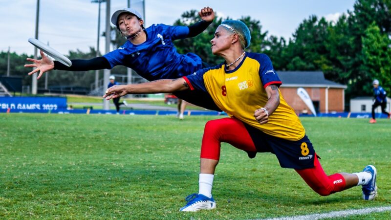 Two flying disc players lunge for the disc