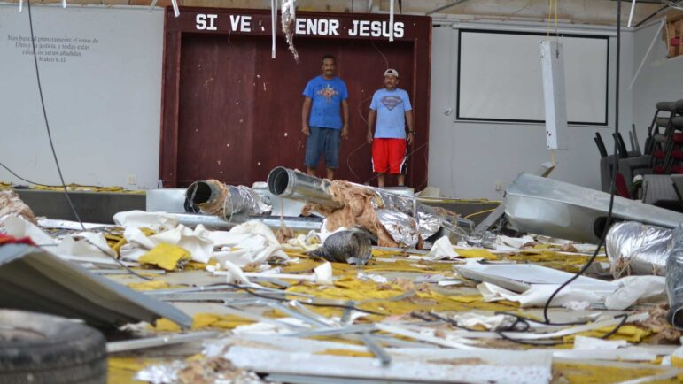 In this file photo, Pastor Pedro Rivera and congregation member Juan Ortega take stock of the damage at Iglesia Pentecostal Providencia Divina in Laplace, Louisiana two days after Hurricane Ida hit the state, Aug. 31, 2021.