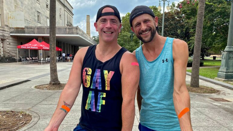 Anthony Reed (left) and Christopher Bowles (right) show off Band-Aids they received for their monkeypox vaccine jabs at the Southern Decadence Health Hub in Louis Armstrong Park in New Orleans, Sept. 4, 2022.
