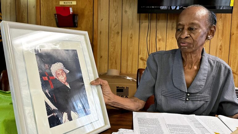 Earlene Johnson holds up a photo of “Grandma Kizzie,” a past Colony, Alabama town leader and ancestor who was born into slavery in 1861, Aug. 17, 2022.