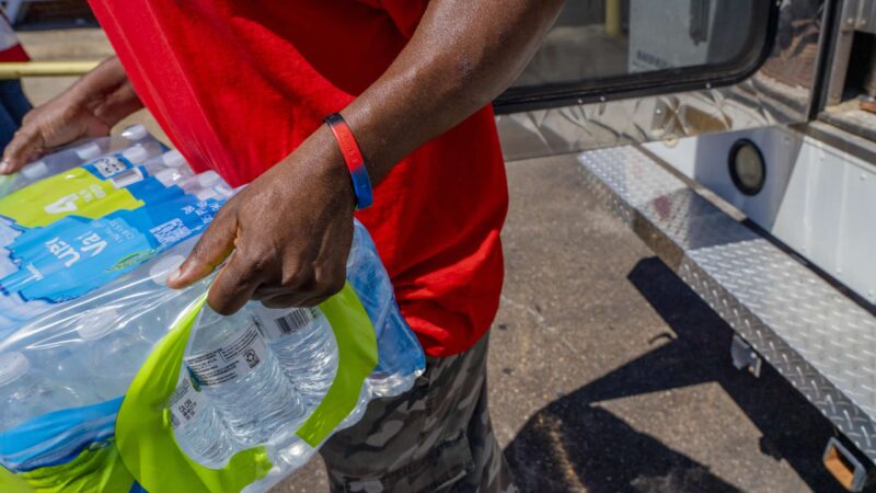 Walter Houston unloads a case of water bottles donated in Jackson, Miss., by the Salvation Army to the Mississippi Industries for the Blind.