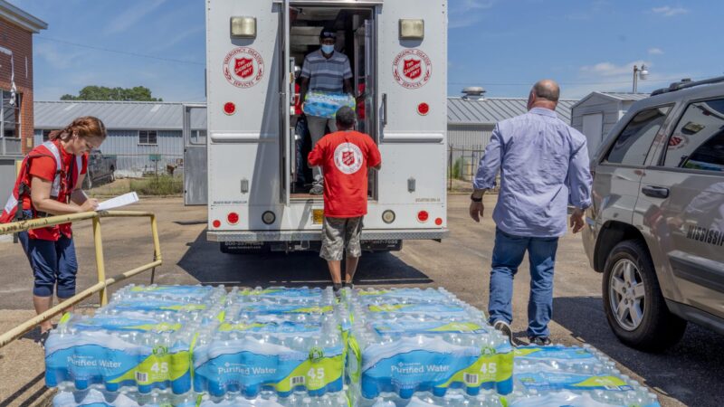 In this file photo, Michelle Hartfield, a public information officer for the Salvation Army, takes notes while Booker Ellis, Chris Bonham and Walter Houston unload water donated by the Salvation Army to the Mississippi Industries for the Blind on Thursday, Sept. 1, 2022.
