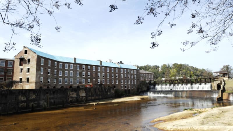 A once-abandoned cotton gin factory that is being renovated into apartments stands beside Autauga Creek in Prattville, Ala.