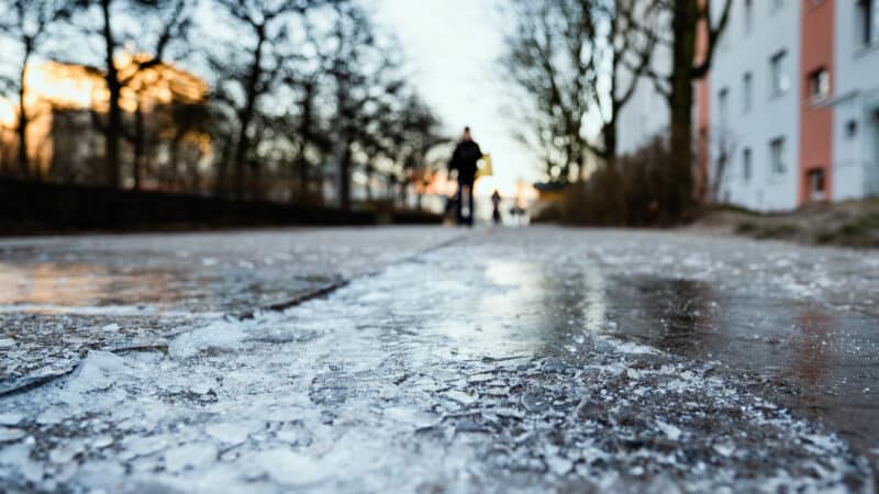 A man walks on an icy street.
