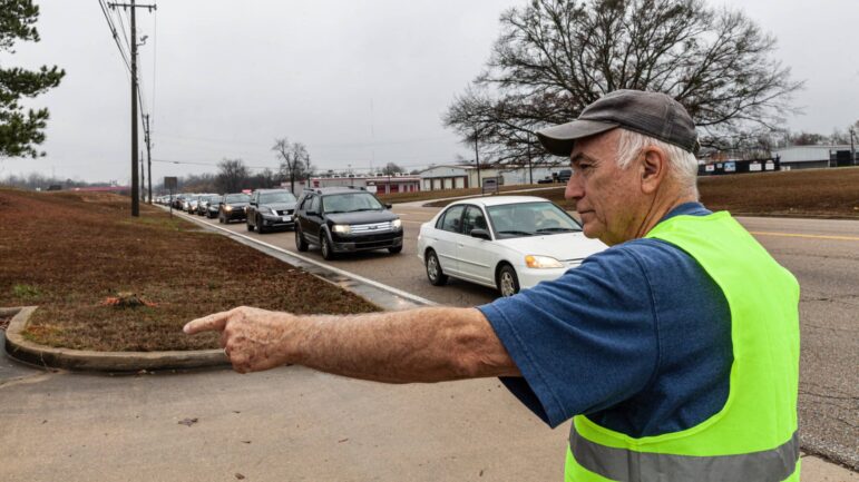 อาสาสมัครนำทางการจราจรเข้าสู่ช่องทางรถเข้าที่ตู้กับข้าว Saint Luke's Food Pantry ใน Tupelo, Mississippi เมื่อวันที่ 8 ธันวาคม 2022