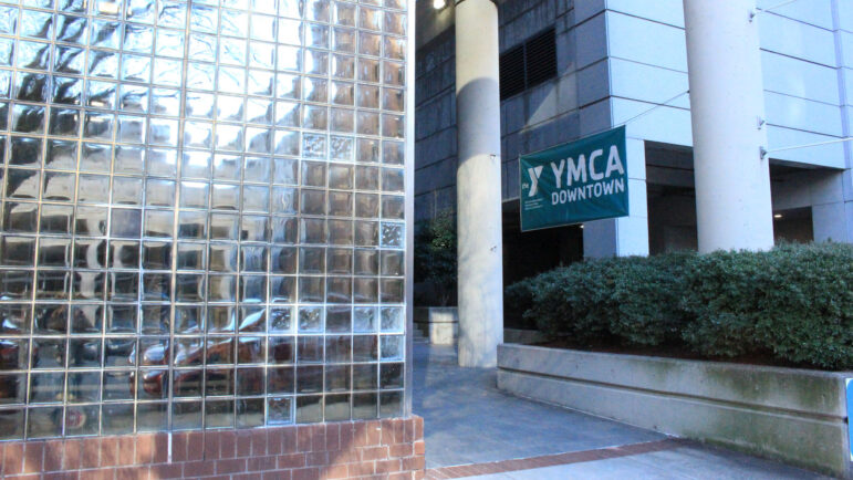 Exterior window of the Downtown YMCA with a sign that says, "YMCA Downtown."
