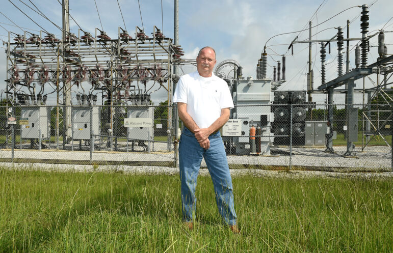 Terry Dunn stands in front of an Alabama Power substation.