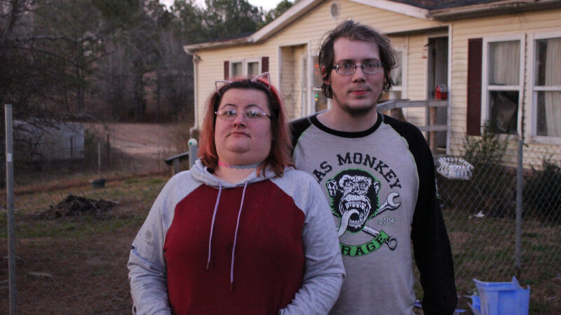 A couple stands in front of their mobile home in St. Clair County, just down the hill from the burning landfill.