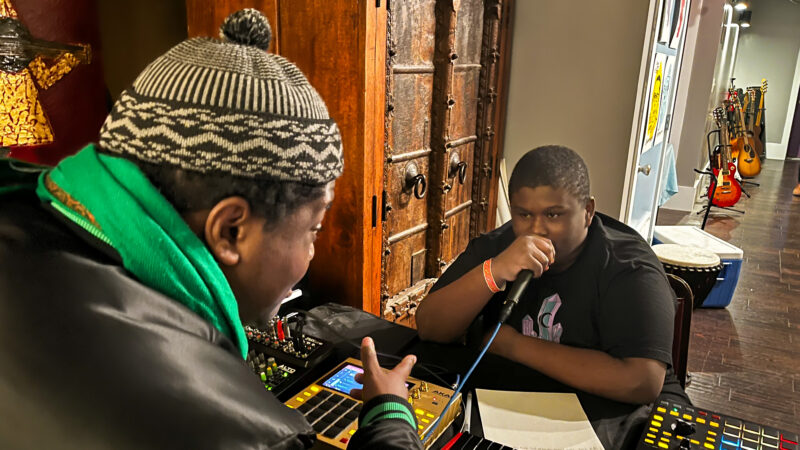 A young boy raps into a microphone