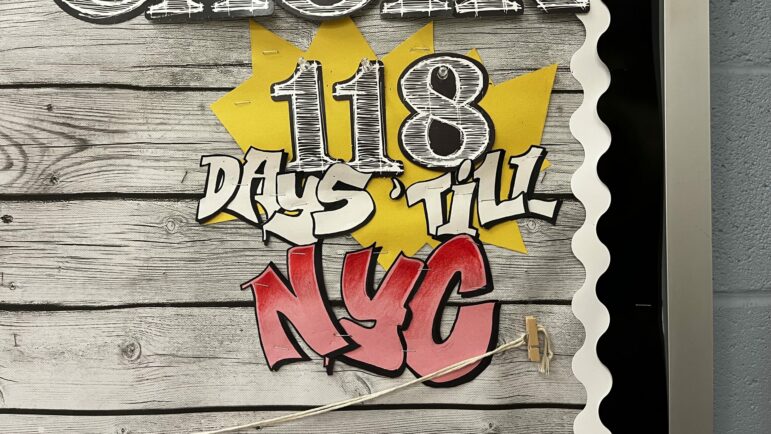 A bulletin board reads "118 Days 'Til NYC"