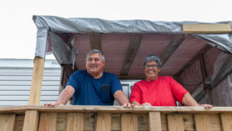 Keith and Ruth Crosby stand on the porch of their FEMA trailer in Golden Meadow, Louisiana, Jan. 16, 2023.