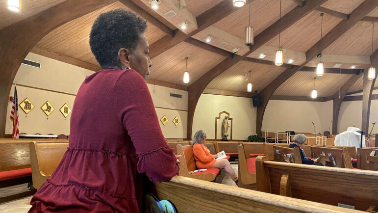 St. Joseph the Worker Health Ministry team member and nurse Deborah Nettles kneels for prayer during daily mass at the Marrero Catholic church, Jan. 30, 2023.