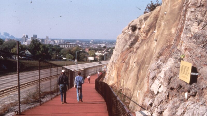 Image shows a walkway above highway 280, which follows along the inner wall of the red mountain cut.