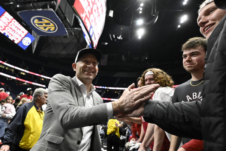 Alabama's basketball coach shakes a man's hand after a game.