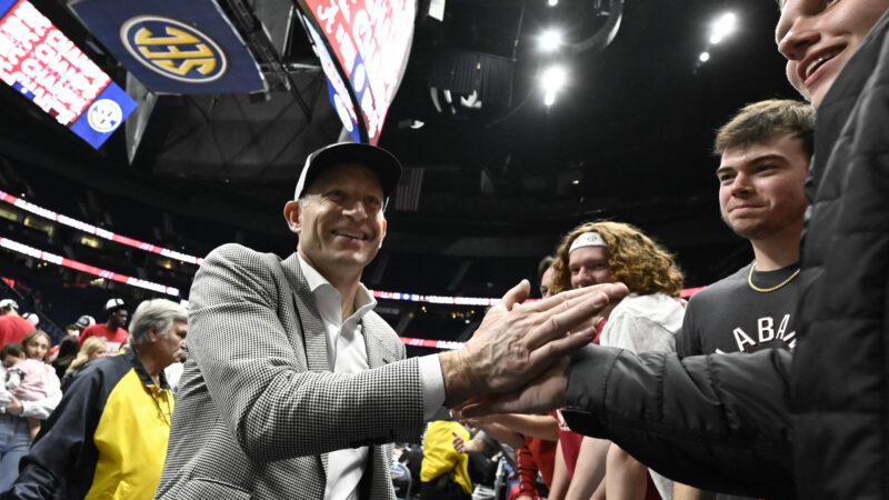 Alabama's basketball coach shakes a man's hand after a game.