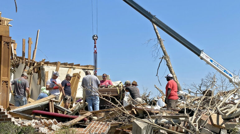 A group of volunteers work to lift Chapel of the Cross Episcopal Church’s altar and organ out of a pile of rubble in Rolling Fork, Mississippi, on March 26, 2023.