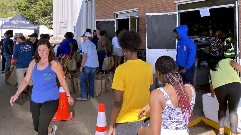 Residents of Rolling Fork, Mississippi, wait outside of Sharkey Issaquena Academy to receive aid in the form of hot meals, canned goods, baby items and more, on March 27, 2023.