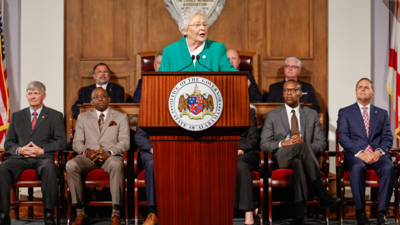 Gov. Kay Ivey stands at a podium and gives a speech.